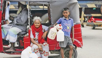 রান্নার কাজে ব্যবহৃত গ্যাস–সংকটের কারণে বিকল্প জ্বালানি কেরোসিন তেল পেতে পেট্রলপাম্পে অপেক্ষা করছে একটি পরিবার। গত সোমবার কলম্বোতেছবি: রয়টার্স